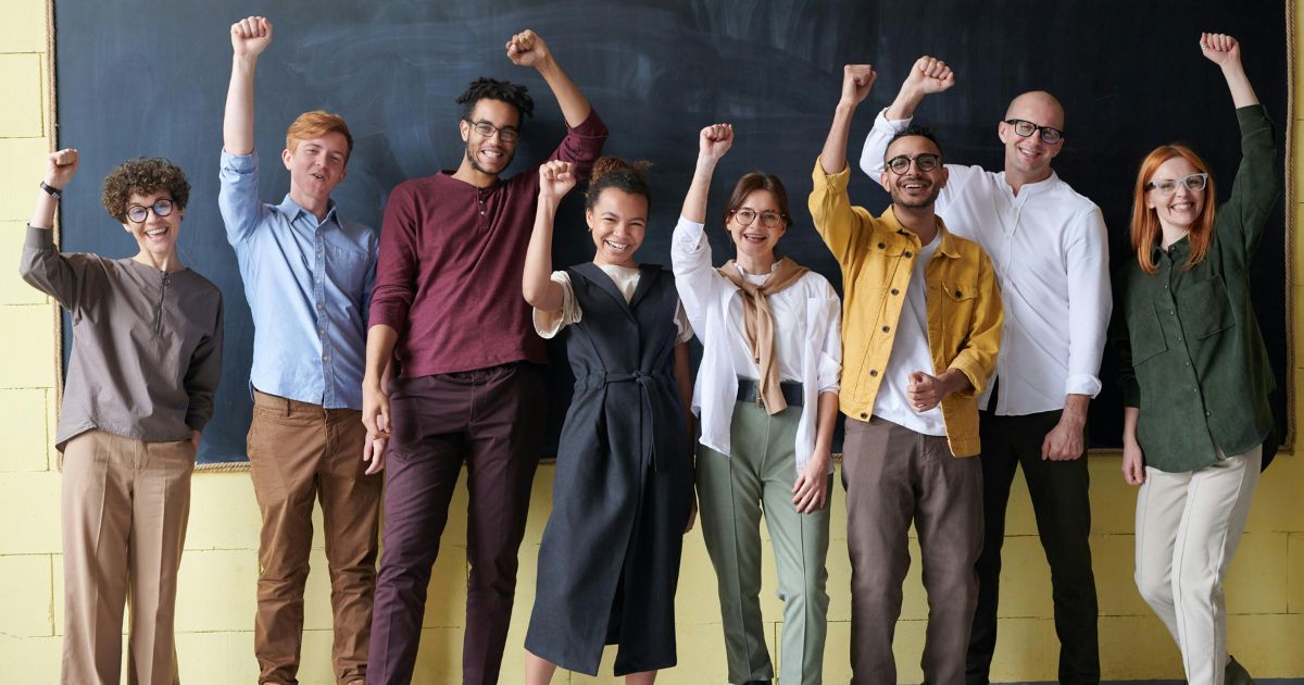 A diverse group of students celebrating success in an academic setting, symbolizing the opportunities and global impact of the University of Adelaide Research Scholarship.