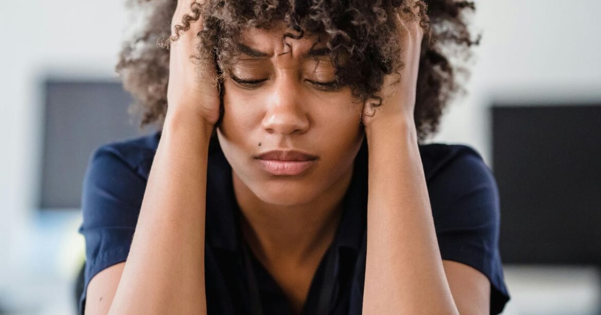 The Dark Side of Scholarships: Stories They Don’t Want You Know A young woman holding her head in frustration, representing the dark side of scholarships including financial burdens and emotional strain.