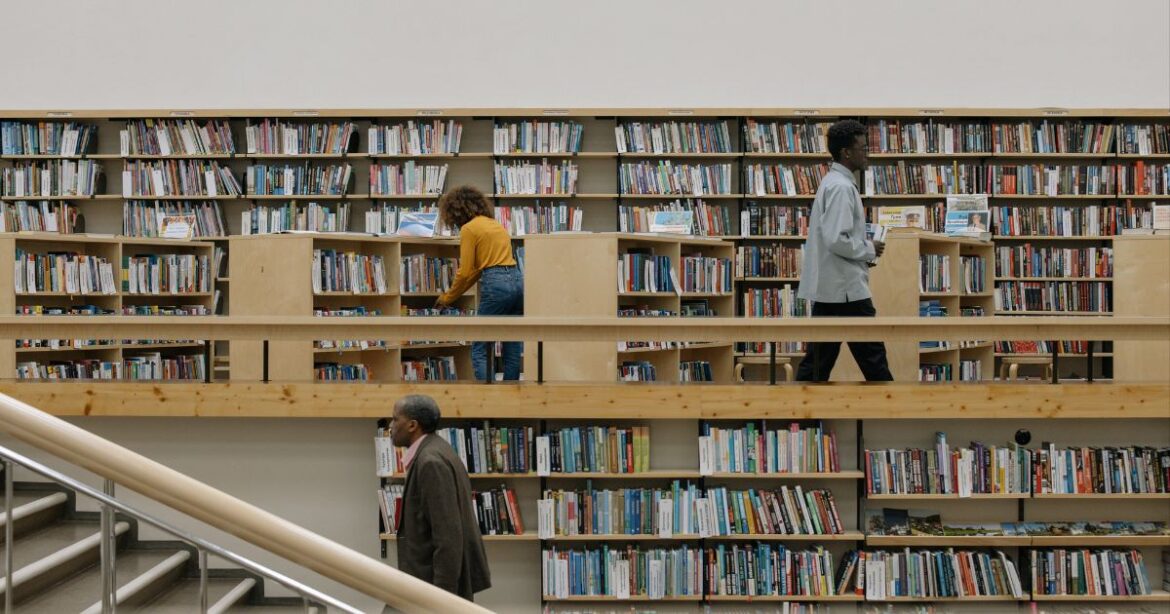 International Dean’s Scholarship 2025 Students browsing books in a well-stocked library, symbolizing academic excellence and opportunities like the International Dean's Scholarship.