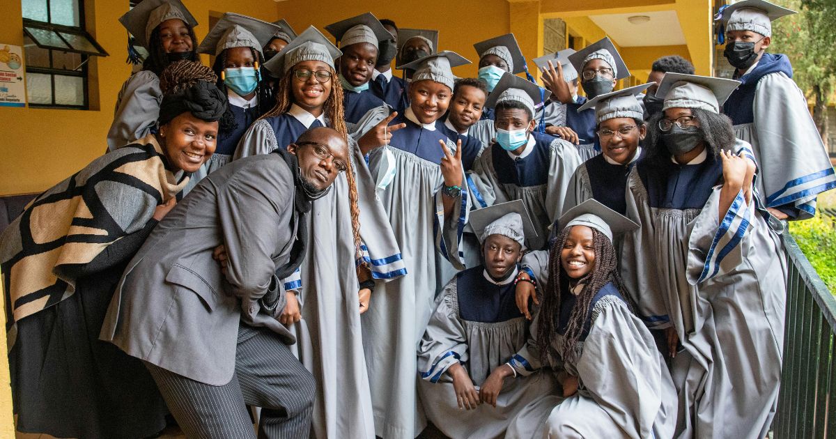 A group of diverse graduates in academic gowns celebrating their achievement, representing the impact of the Mastercard Foundation Scholarship in empowering young scholars.