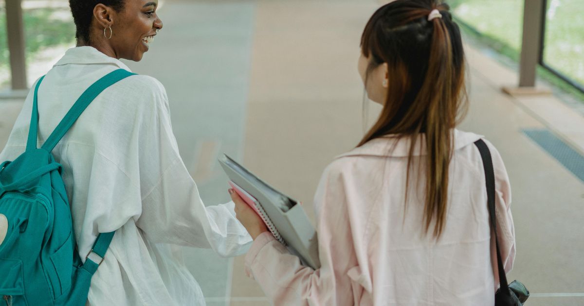 Two university students walking and chatting on campus, representing opportunities like the upGrad Futures Scholarship for international students.