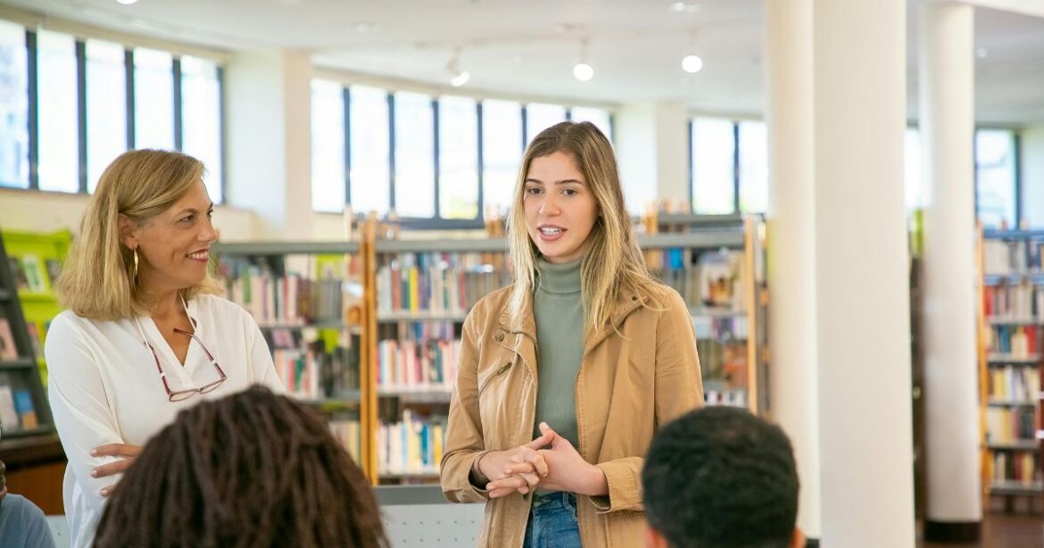 Humber College Entrance Scholarship. A young woman speaking confidently in a library setting, symbolizing leadership, academic excellence, and opportunities like the Humber College Entrance Scholarship.