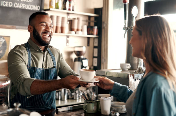 Shot of a young man serving coffee to a customer in a cafe Café Assistant (Casual) Needed at Summerset